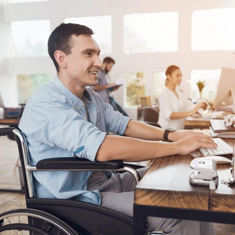 man in wheelchair working in an office